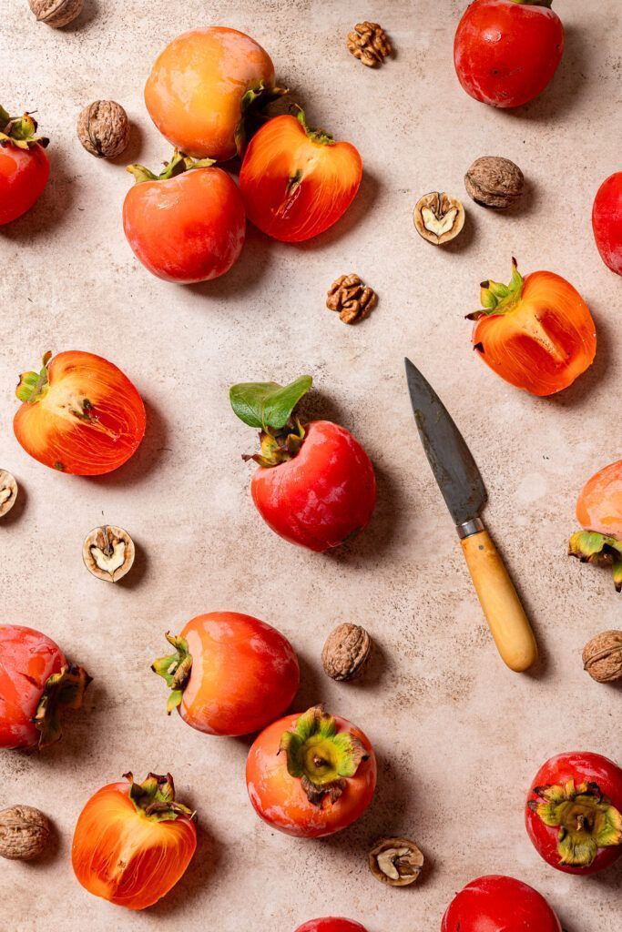 foto gastronómica de productos de temporada otoñal como caquis y nueces