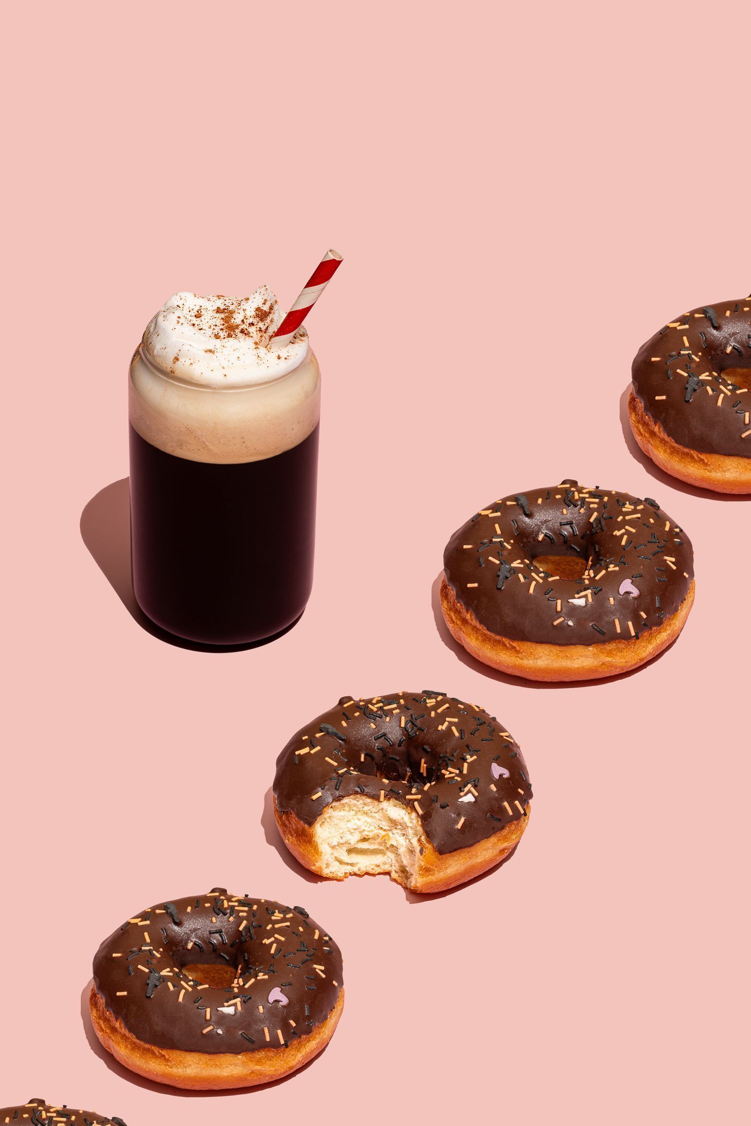 Fotografía comercial de donuts que se repiten a lo largo de la imagen junto a un vaso de café